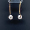 white freshwater pearl on handmade round wire earrings in 14k of yellow gold